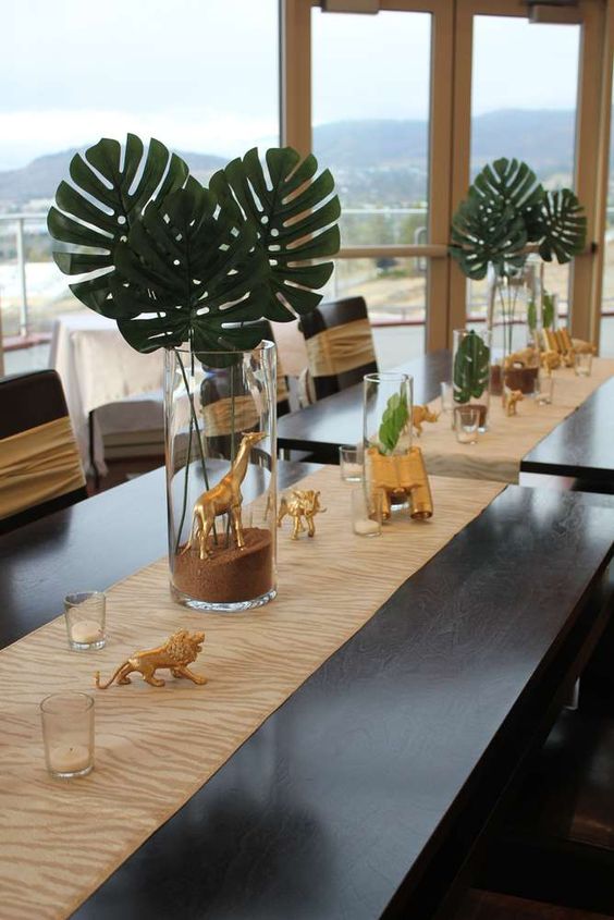 Plantas tropicales como centros de mesa para fiesta de safari